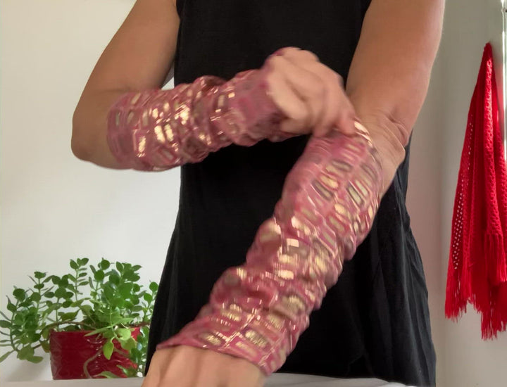 this is a product video: woman arms showing how to weare lamiadesign sleeves, lambskin leather print rectangle, gold, pink, purple lambskin sleeves